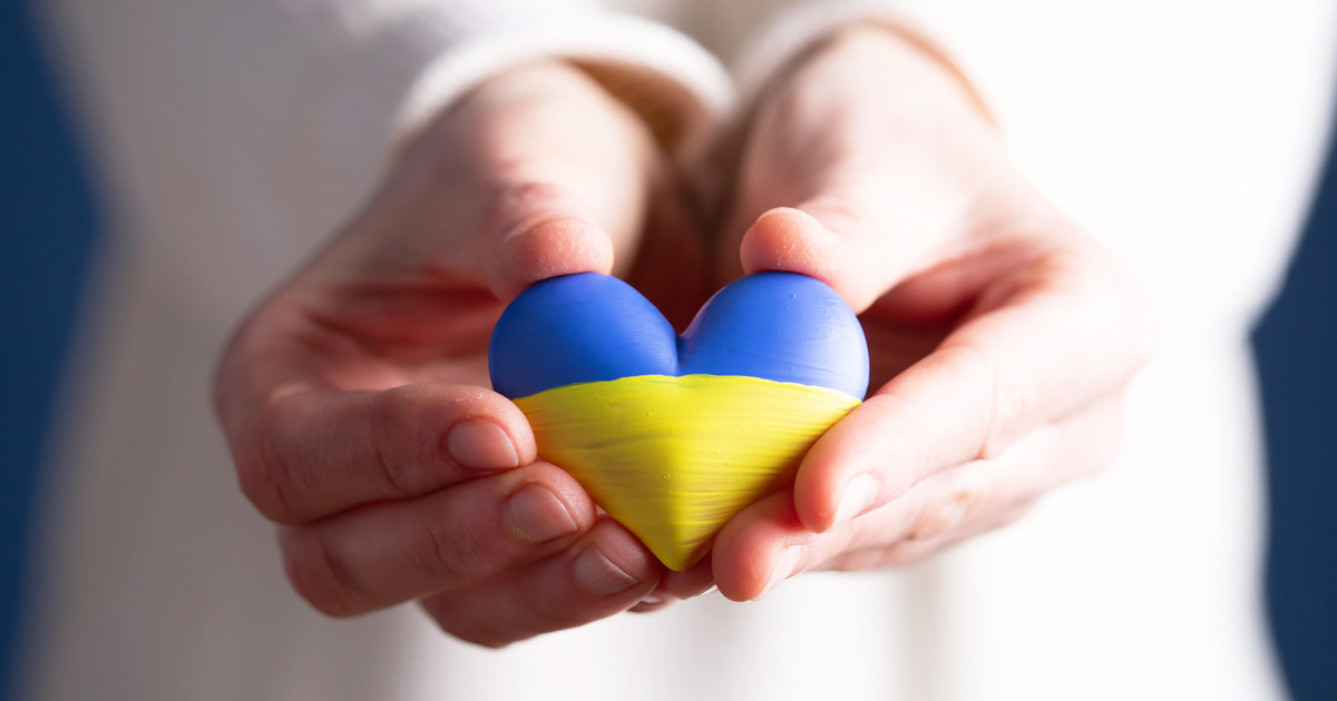 Heart flag of Ukraine in human hands. No war, peace for Ukraine