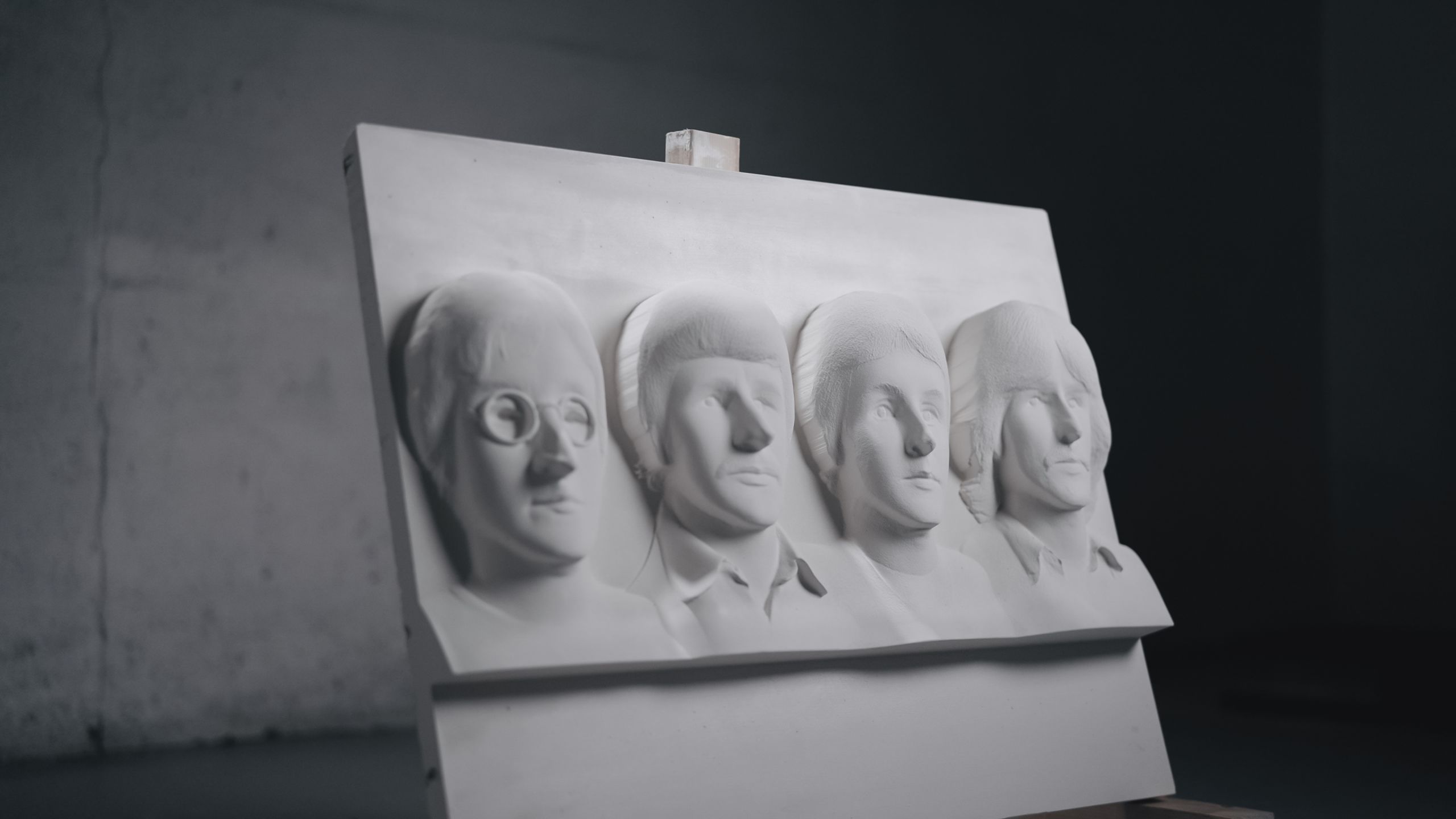 PressPhotos-19 The four members of the Beatles as they appeared in 1967 are carved into plaster. The artwork sits on a stand in an empty workshop